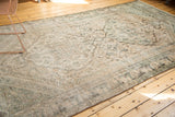 Corner detail: distressed Northwest Persian carpet, geometric border, charcoal, ivory, apricot.