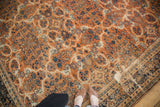 Burnt orange Mahal rug field with scrolling vinery, arabesques, ivory wear, and navy border.
