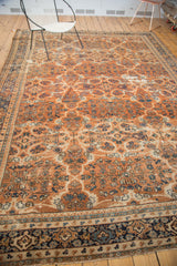 Vintage Mahal rug detail with distressed terra cotta field and ornate navy blue border.