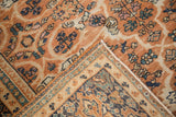 Ornate navy blue border of vintage Mahal carpet, terra cotta field with scrolling arabesques.