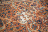Vintage Mahal carpet's terra cotta field displaying scrolling vinery and areas of storied wear.