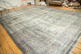 Vintage Meshed carpet corner with distressed patina blue border and faded floral pattern.