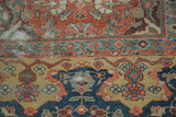 Antique Sultanabad carpet detail: terra cotta and yellow-beige fields, navy patterns, geometric border, patina.