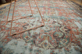 Worn texture of antique Sultanabad carpet; terra cotta and sky blue sprawling motifs.