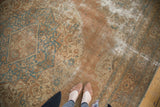 Antique Jalili Tabriz rug's distressed field with patina, apricot, and sky blue motifs.