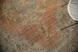 Worn apricot field texture with faded blue patterns on an antique Tabriz carpet.