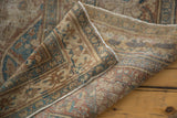 Distressed pile of antique Jalili Tabriz carpet with reverse showing old adhesive remnants.