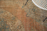 Distressed apricot field of an antique Tabriz, with sky blue and ivory floral motifs.