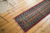 Hand-knotted repeating geometric medallions in cherry red, indigo blue, and pale saffron yellow.