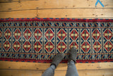 Double column repeating medallion motif in cherry red, indigo, saffron on a vintage Afghan runner.