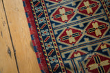 Secured hand-knotted side of Afghan runner with cherry red, indigo, saffron motifs.