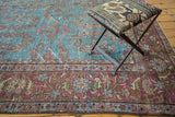 Unusual aqua blue field with repeating floral arrangements meets burgundy border.