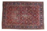 Vintage Yezd carpet with deep red field, allover palmette lattice, dark blue borders, storied wear.