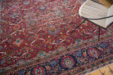 Black cherry red field with delicate palmette motifs; contrasting dark blue border.
