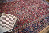Fine hand-knotted Yezd carpet with black cherry wine red field, elaborate palmette motifs, and time-softened areas.