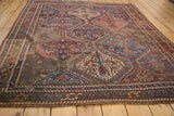 Vintage Qashqai rug edge detail: repeating geometric panels, madder root red, sky blue, and fringe.