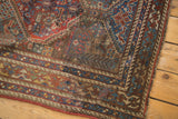 Persian Qashqai rug corner, rich madder red and sky blue geometric repeating panels.