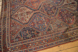Vintage Qashqai rug's repeating geometric panels with animals and plants in madder red, sky blue.