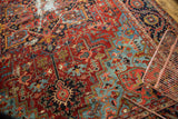 Antique Heriz carpet's ruby red, pale sapphire geometric patterns and central foundation wear.