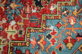 Antique Heriz rug detail: bold geometric pattern in ruby, sapphire, saffron, and visible wear.