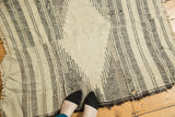 Visible seam, striated geometric ivory and charcoal patterns, and interior holes on Kurdish rug.
