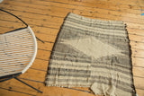 Vintage Kurdish rug corner with ivory and charcoal geometric stripes, frayed edge.