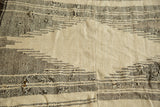 Geometric charcoal stripes on ivory vintage Kurdish rug, showing textured weave and interior holes.