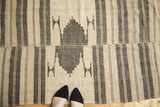 Vintage Kurdish throw rug featuring offset geometric medallion and ivory, charcoal banded stripes.
