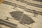 Detail of vintage Kurdish rug with ivory and charcoal geometric patterns, herringbone texture, and seam.