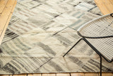 Textured diamond patchwork panels and blanket stitch in ivory, brown, and charcoal.