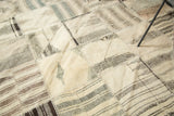 Kurdish patchwork rug detail: diamond panels, geometric patterns, and blanket stitching in ivory, brown, charcoal.