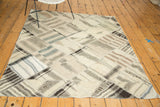 Vintage Kurdish patchwork rug with diamond panels, blanket stitching, and varied neutral shades.