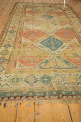 Geometric panels and flat weave of antique Soumac carpet in gold, terra cotta, and blue.