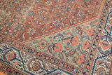 Vintage Mission Malayer rug corner shows madder red floral cross-sections and aqua border.