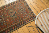 Vintage Karaja rug corner showing madder red field with rectilinear tendrils and a floral border.