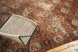 Vintage hand-knotted Baktiari carpet section with red, blue, green tree motifs and visible wear.