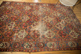 Vintage Baktiari carpet showing border cartouches with love bird designs and worn madder red field.