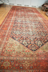 Intricate corner of an antique Persian Malayer runner: dark navy field meets light beige botanical motifs.