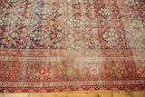 Antique Malayer rug's red, navy, beige geometric border and complementary floral field motifs.