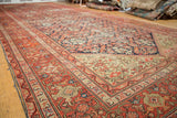 Intricate red border and allover navy floral field on an antique Persian Malayer rug.