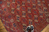Distressed antique Tekke carpet with brick red field, geometric gul design, and rich patina.