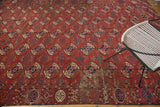 Distressed antique Tekke carpet with classic brick red gul motifs and mallard green accents.