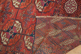 Distressed Antique Tekke carpet's textured gul pile and intricate hand-knotted reverse with fringe.