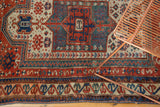 Geometric central motif of antique Caucasian rug in brick red, sky blue, and ivory.