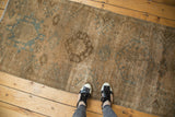 Distressed vintage Karaja runner showing its textured beige field and faded sky blue medallion pattern.