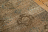 Distressed texture of a vintage Karaja rug, showing faded beige, chocolate brown, and sky blue motifs.