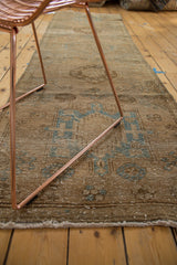 Distressed pile and secured fringe of the Karaja runner, with faded sky blue patterns.