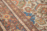 Close-up of vintage Mahal carpet's low pile, showing rust, ivory, and blue motifs.