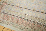 Antique Khotan rug end with distressed pile, visible foundation, and floral trellis pattern.