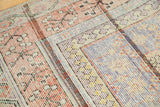 Antique Khotan rug section: faded apricot, teal blue, ivory trellis, visible foundation.